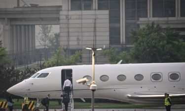 Elon Musk (in white) boards his private jet before departing from Beijing Capital International Airport on May 31. He was traveling to Shanghai.
