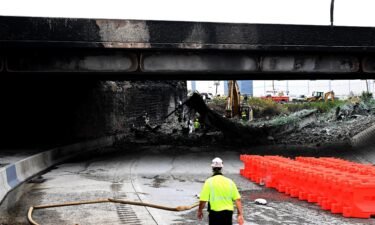 Workers inspect and clear debris after the collapse of an overpass on Interstate 95 in Philadelphia.