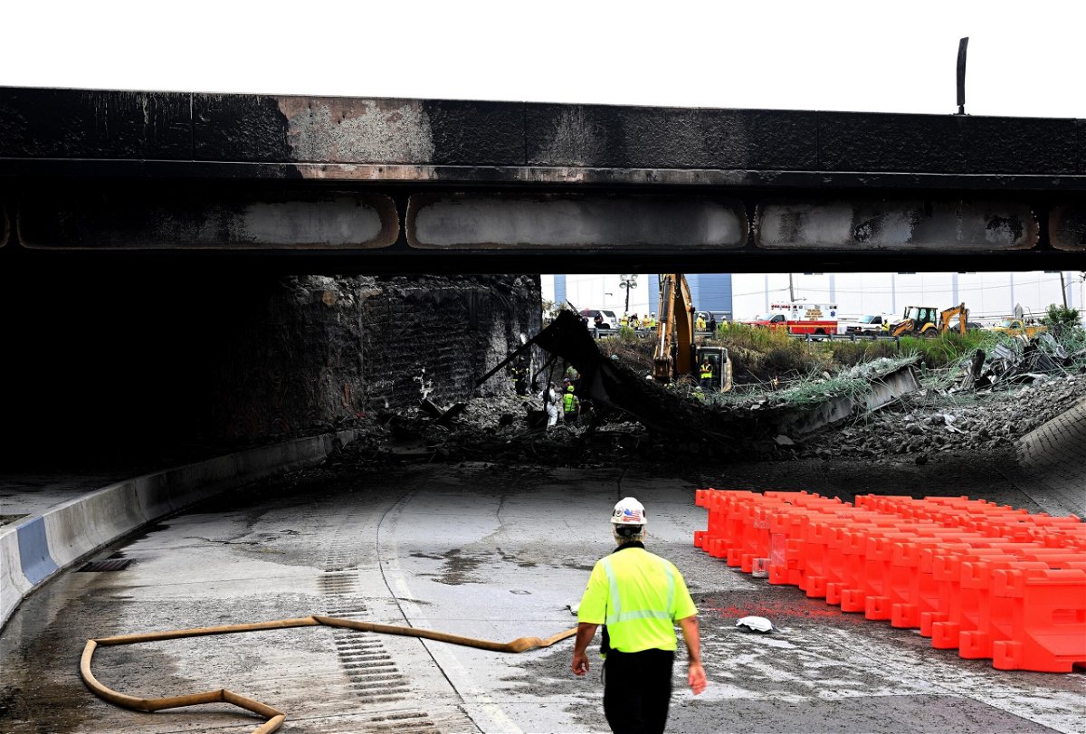 <i>Mark Makela/Getty Images</i><br/>Workers inspect and clear debris after the collapse of an overpass on Interstate 95 in Philadelphia.