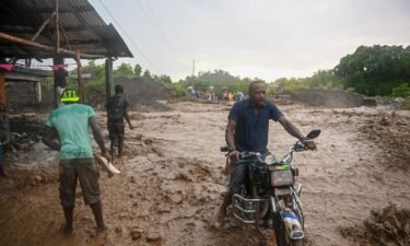 Resident wade through flooded roads in neighborhoods of Petit-Goâve