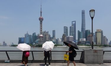 Tourists holding umbrellas visit Shanghai during a heat wave on May 29. The city recently recorded its highest May temperature in more than 100 years.