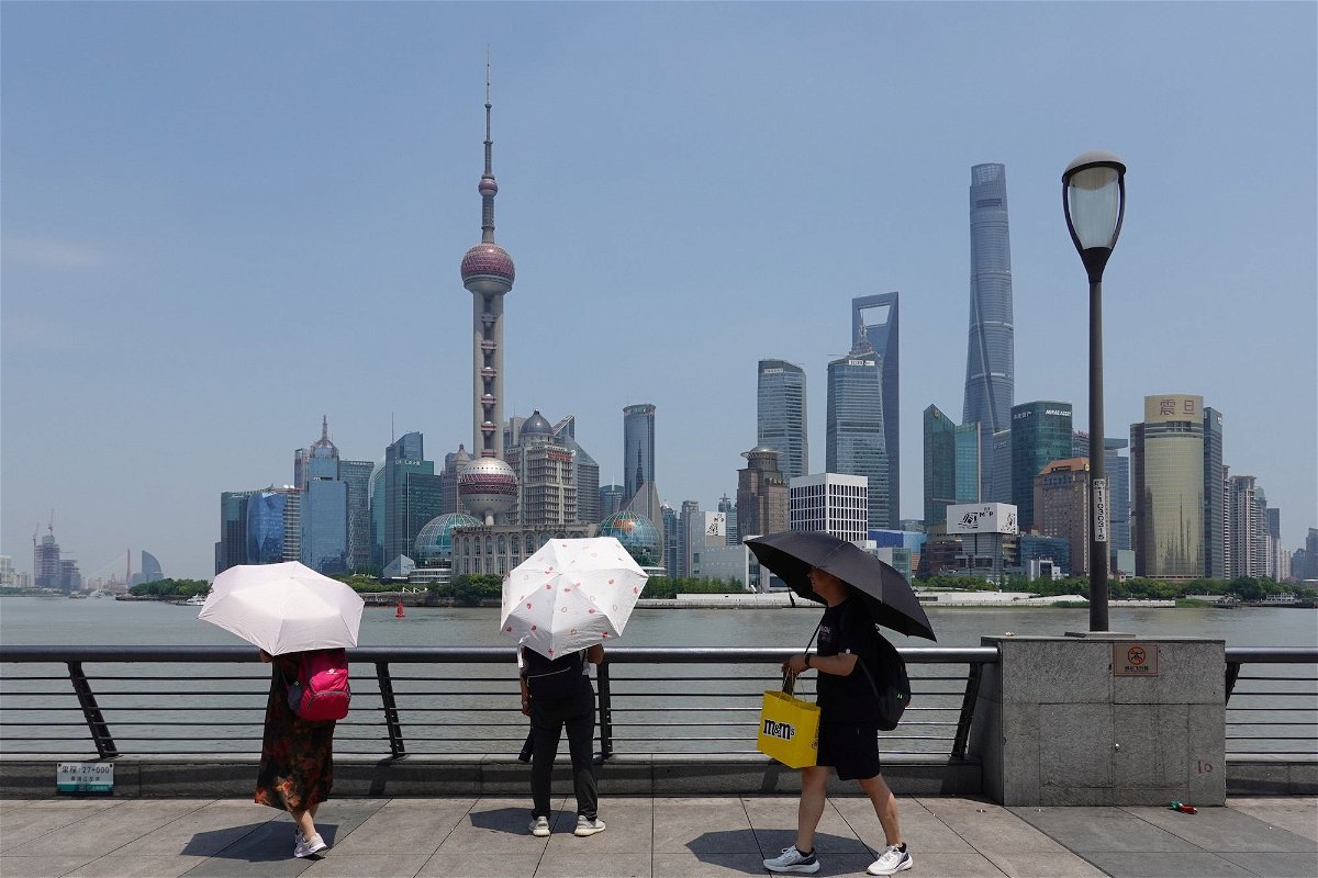 <i>Wang Gang/VCG/Getty Images</i><br/>Tourists holding umbrellas visit Shanghai during a heat wave on May 29. The city recently recorded its highest May temperature in more than 100 years.