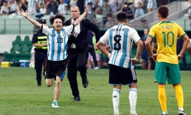 The young pitch invader is chased by security officials during a soccer match between Argentina and Australia at the Workers' Stadium in Beijing
