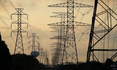 The sun rises over power lines in Houston on June 27. Scorching temperatures have taxed the Texas power grid.