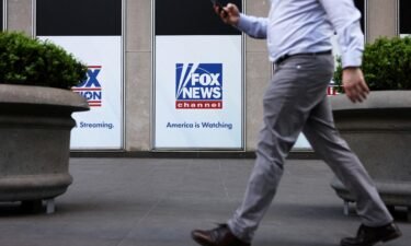A person walks by Fox News signage posted on the News Corporation building in New York City