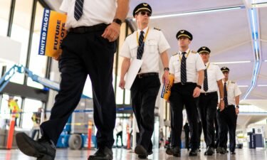 Pilots from United Airlines walk inside the airport as they take part in an informational picket at Newark Liberty International Airport in Newark