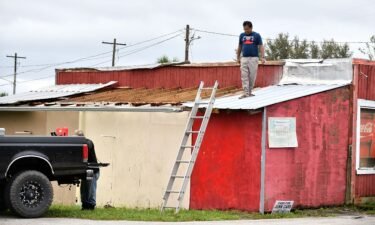 Talukder Mahtab surveys the roof of his business after it was hit by the winds and rain from Hurricane Ian on September 29
