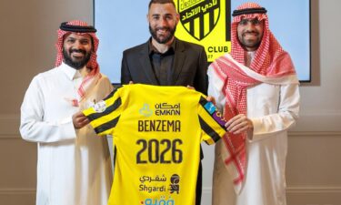 Karim Benzema holds the Al-Ittihad jersey after signing for the Saudi Arabian team.