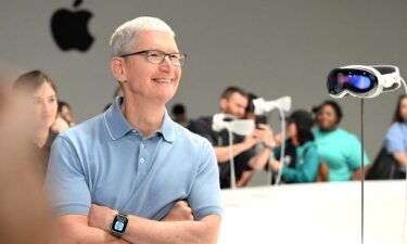 Apple CEO Tim Cook speaks with members of the media next to Apple's new Vision Pro virtual reality headset
