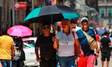 People protect themselves from the sun with umbrellas amid high temperatures in Mexico on June 22.