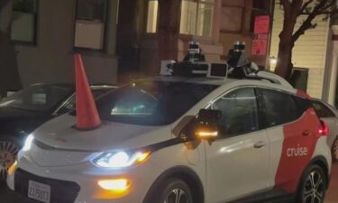 A robotaxi on a San Francisco street is disabled after a group of activists place an orange cone on the hood.