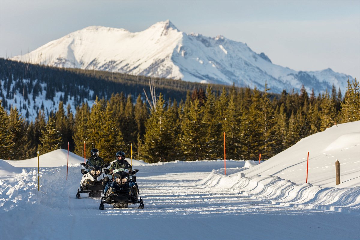 Snowmobilers with Electric Peak Backdrop