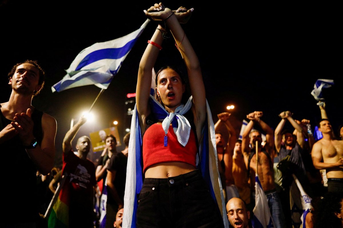 <i>Corinna Kern/Reuters</i><br/>A person gestures as protesters block Ayalon Highway during a demonstration following a parliament vote on a contested bill that limits Supreme Court powers to void some government decisions