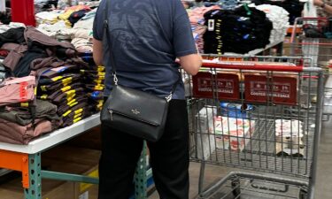 A shopper surveys stacks of clothing on a sales table in a Costco warehouse on June 22 in Colorado Springs