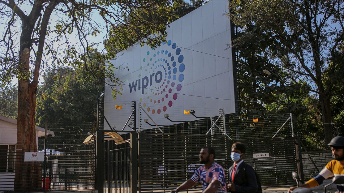 Motorcyclists drive past a Wipro Ltd. sign in the Electronic City area of Bengaluru