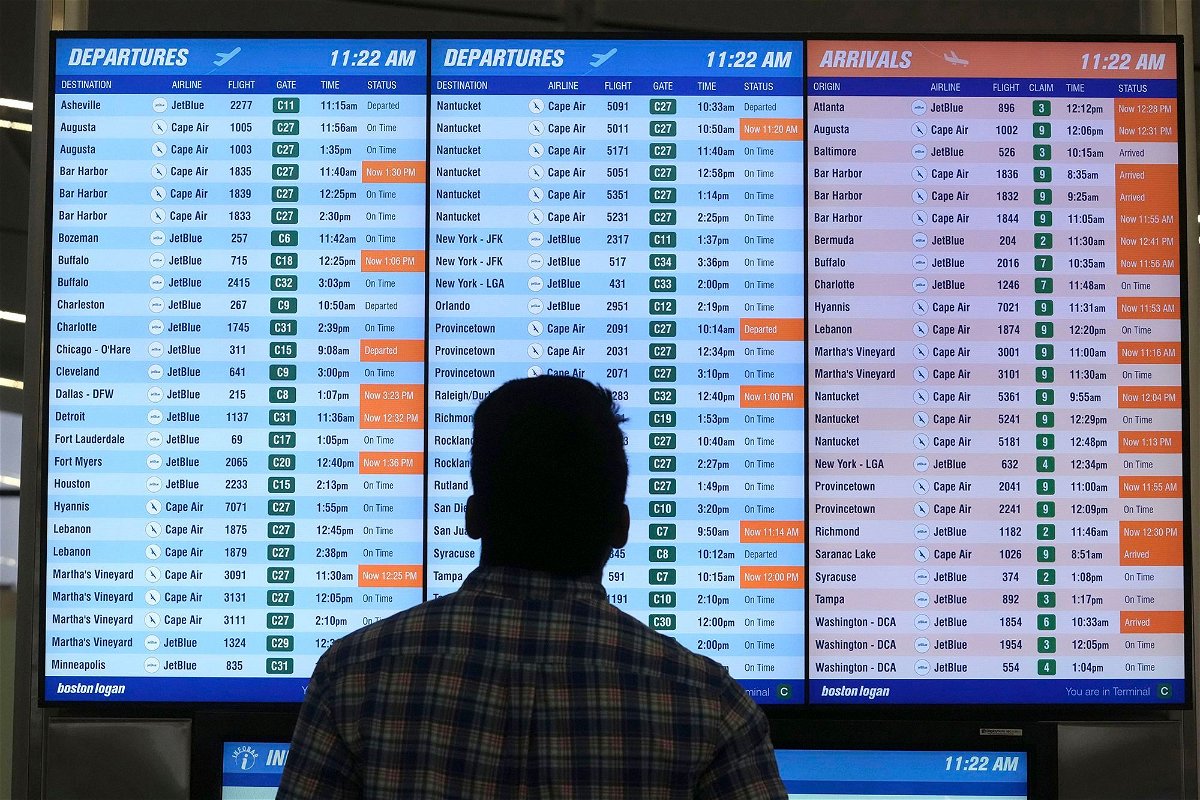 <i>Steven Senne/AP</i><br/>A man views a flight board at Boston Logan International Airport
