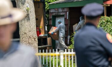 Crime laboratory officers remove boxes as law enforcement searches the home of Rex Heuermann