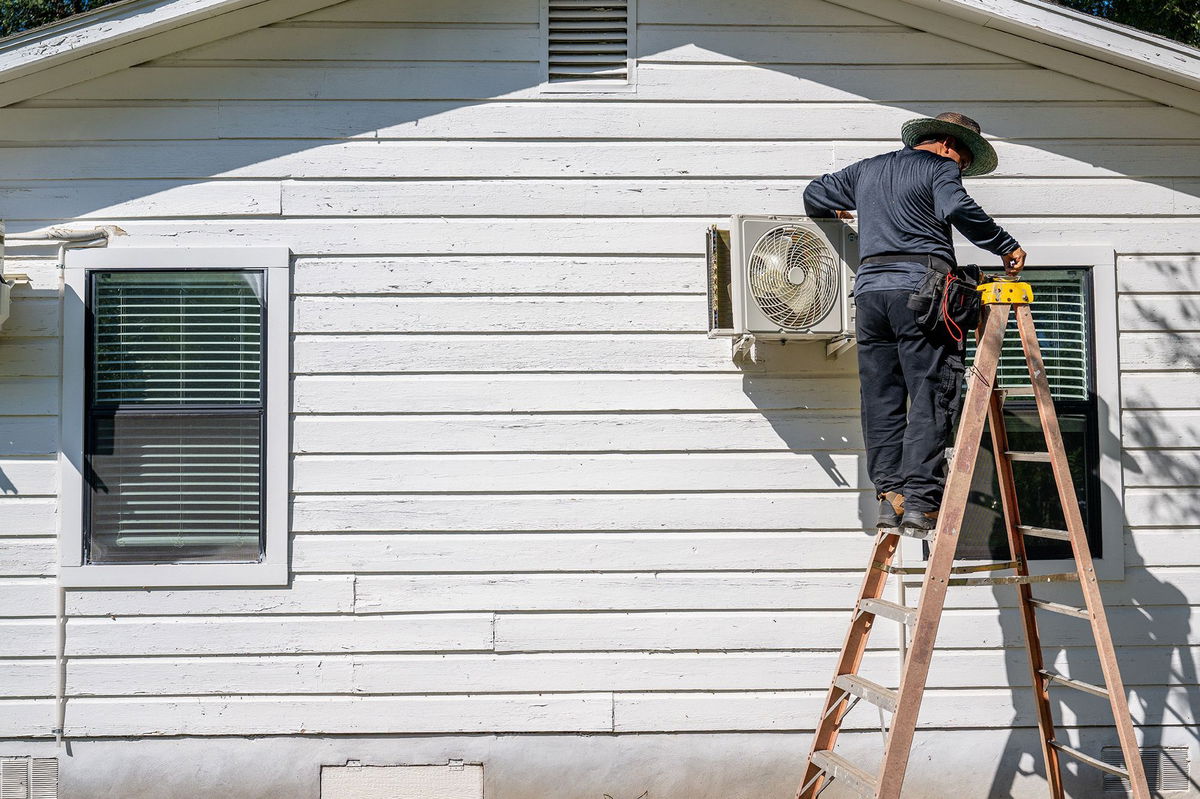 <i>Brandon Bell/Getty Images</i><br/>AC Tech Romero repairs an air conditioning unit on July 10 in Austin