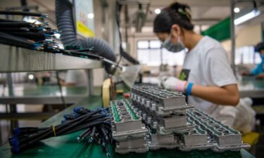 An employee works on the assembly line of LED lighting products at Pujiang Sansi Optoelectronics Technology Co.