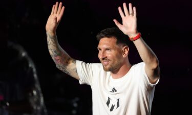 Lionel Messi waves to fans as he is introduced during "The Unveil" introducing Lionel Messi hosted by Inter Miami CF at DRV PNK Stadium on July 16