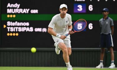 Andy Murray runs to play a return against Tsitsipas.