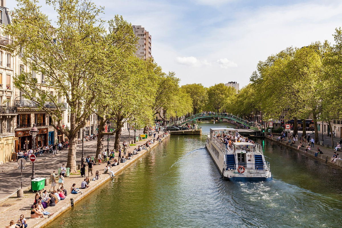 <i>mauritius images GmbH/Alamy Stock Photo</i><br/>A sightseeing boat goes down Canal Saint Martin in Paris and you can get a discount for a place to stay here and other top-tier cities if you are willing to take a chance on very last-minute accommodations.