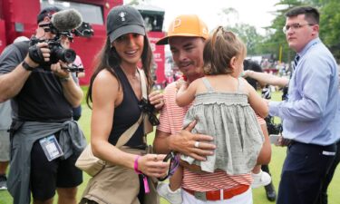 Fowler walks off the 18th green with his wife Allison and daughter Maya after the final round.