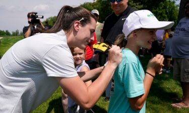 Iowa basketball player Caitlin Clark signs an autograph during the John Deere Classic golf pro-am at TPC Deere Run in Illinois on July 5.