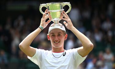 Henry Searle holds aloft the boys' singles trophy.