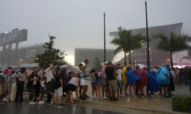 Fans wait in line during a downpour at Inter Miami's stadium.