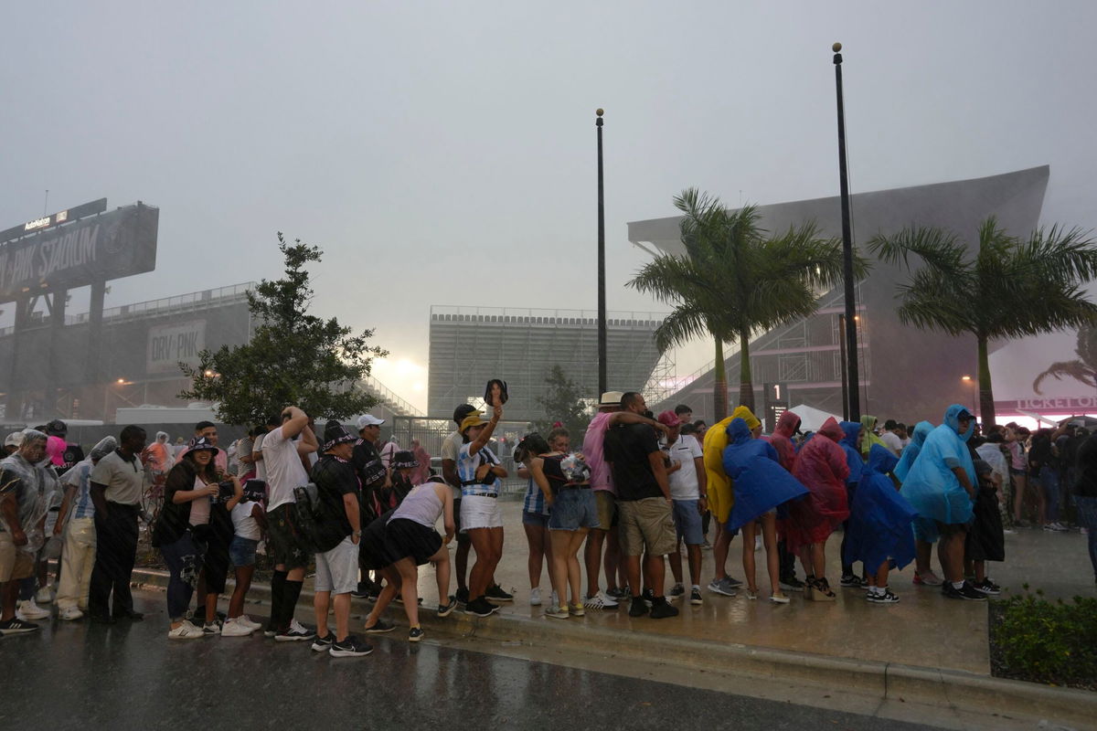 <i>Rebecca Blackwell/AP</i><br/>Fans wait in line during a downpour at Inter Miami's stadium.