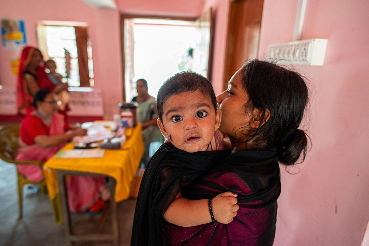 <i>Pradeep Gaur/SOPA Images/Sipa USA/FILE</i><br/>A woman carrying her young child takes part in a monthly child vaccination camp June 19 in Brindaban village