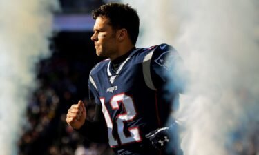 Tom Brady #12 of the New England Patriots runs onto the field before a game against the Miami Dolphins at Gillette Stadium on December 29
