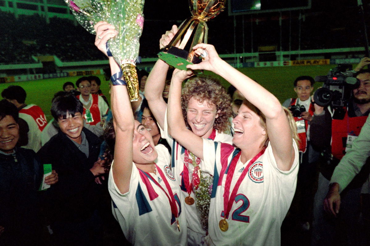 <i>Tommy Cheng/AFP/Getty Images</i><br/>Michelle Akers (C) holds the Women's World Cup trophy with teammates Julie Foudy (L) and Carin Jennings (R).