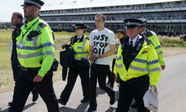 A Just Stop Oil protester is taken away by police during day two of The Open at Royal Liverpool