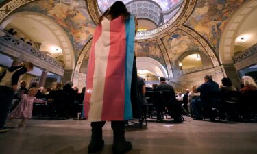 Glenda Starke wears a transgender flag as a counter protest during a rally in favor of a ban on gender-affirming health care legislation