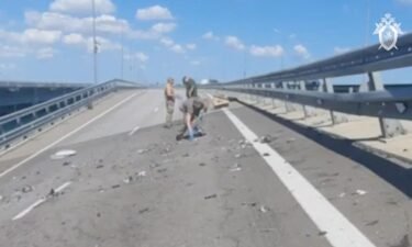 Russian investigators work at the scene on the section of the bridge damaged on July 17.