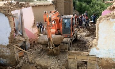 An excavator removes mud and rocks from a damaged house after heavy flooding in Maidan Wardak province.