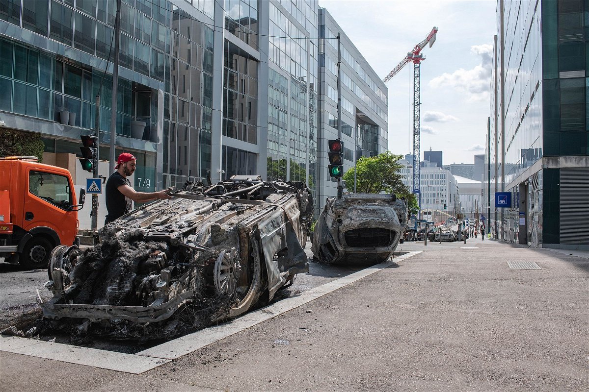 <i>Joshua Berlinger/CNN</i><br/>Workers clear a street filled with charred cars in Nanterre