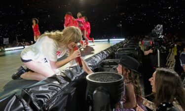Taylor Swift gives her hat to a young fan during a New Jersey "Eras Tour" concert in May.