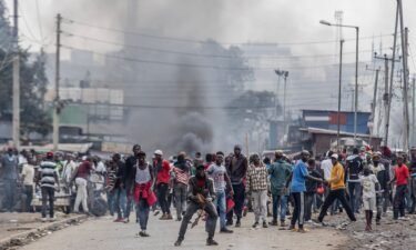 Kenyan opposition supporters react and throw stones towards Kenya Police officers during demonstrations in Nairobi