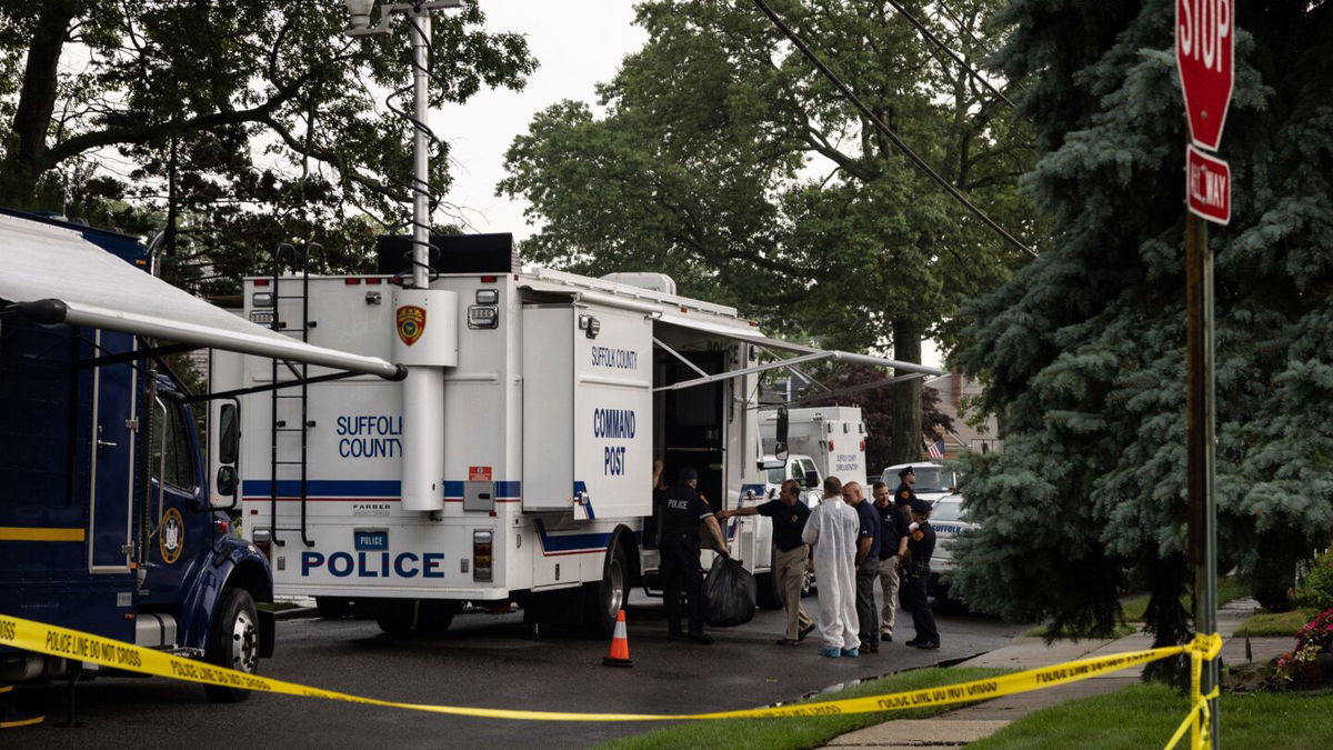 <i>Yuki Iwamura/AFP/Getty Images</i><br/>Crime laboratory officers are seen outside Rex Heuermann's home in Massapequa Park on July 18.