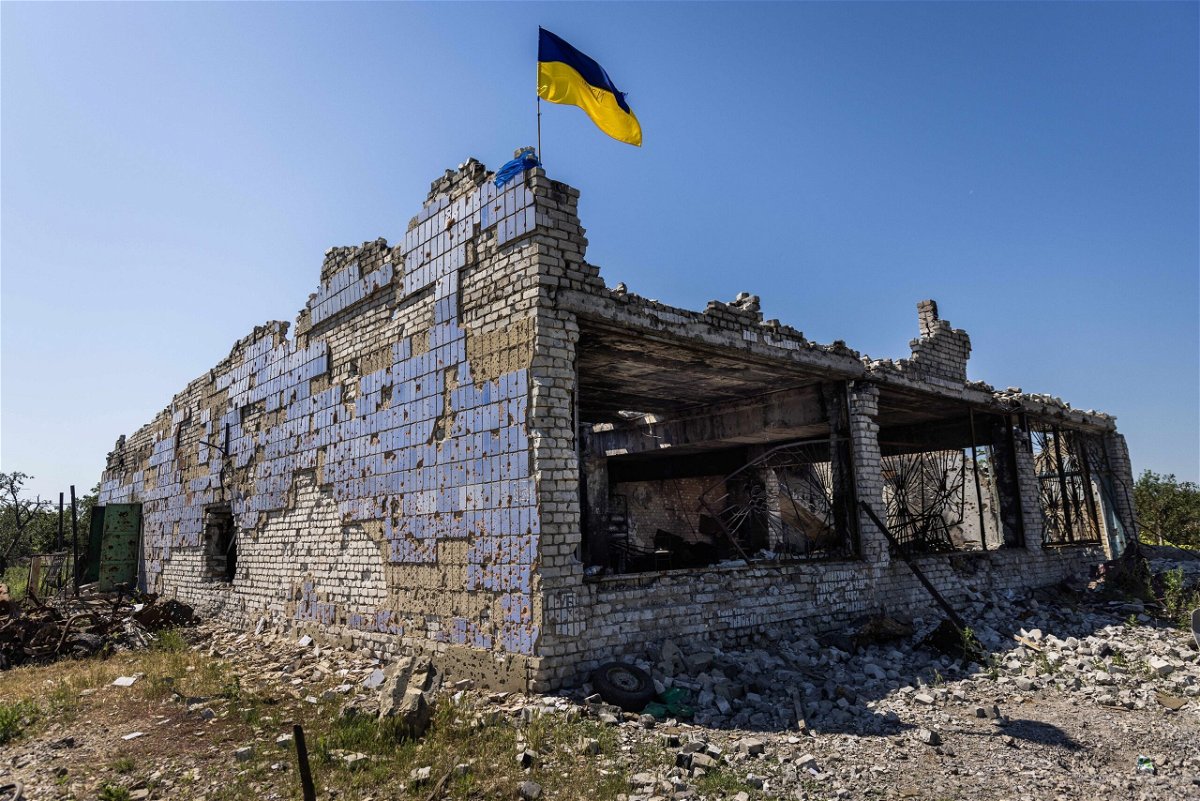 <i>Daniel Carde/Anadolu Agency/Getty Images</i><br/>A Ukrainian flag waves above a destroyed building after shelling in Vremivka