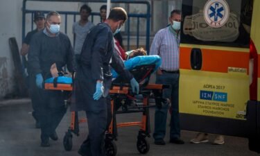 Medical staff carry a survivor on a stretcher outside a warehouse at the port in Kalamata town