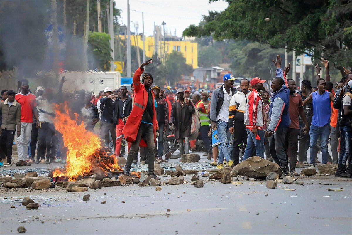 <i>AP</i><br/>Protesters stand by a burning barricade on a street in the Mathare neighborhood of Nairobi