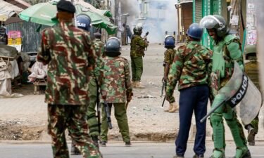 Riot police officer lobs teargas canisters to disperse supporters of Kenya's opposition leader.
