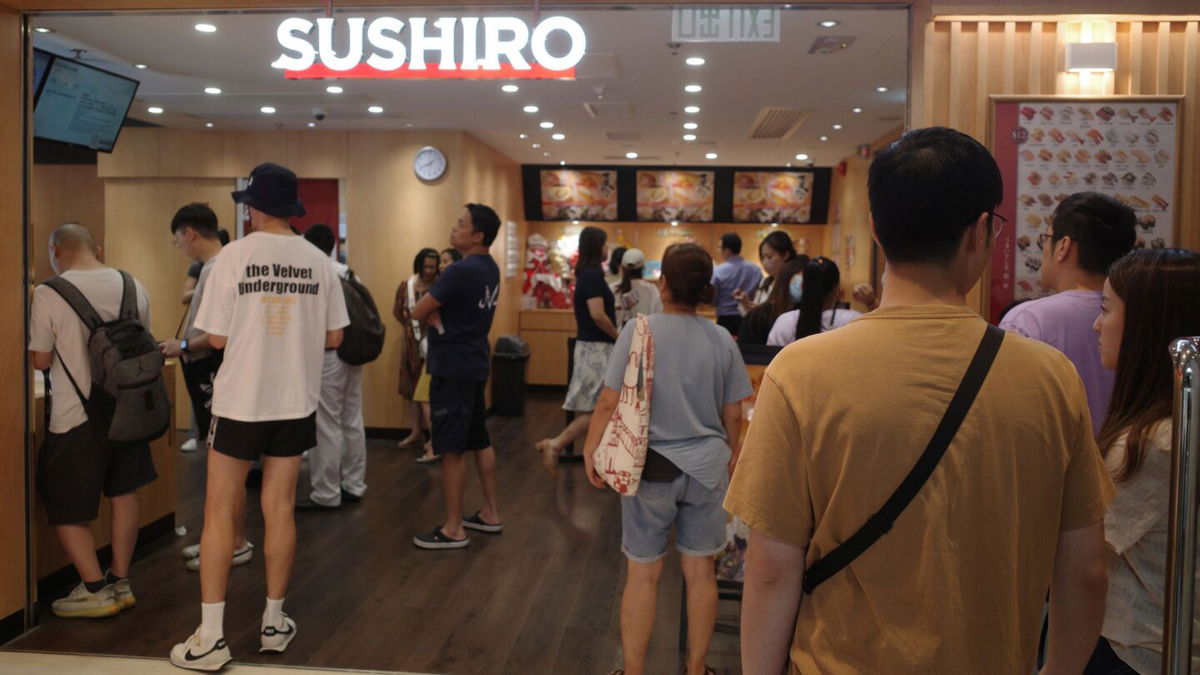 <i>Chris Lau/CNN</i><br/>Customers wait to get into Japanese sushi chain Sushiro in Causeway Bay