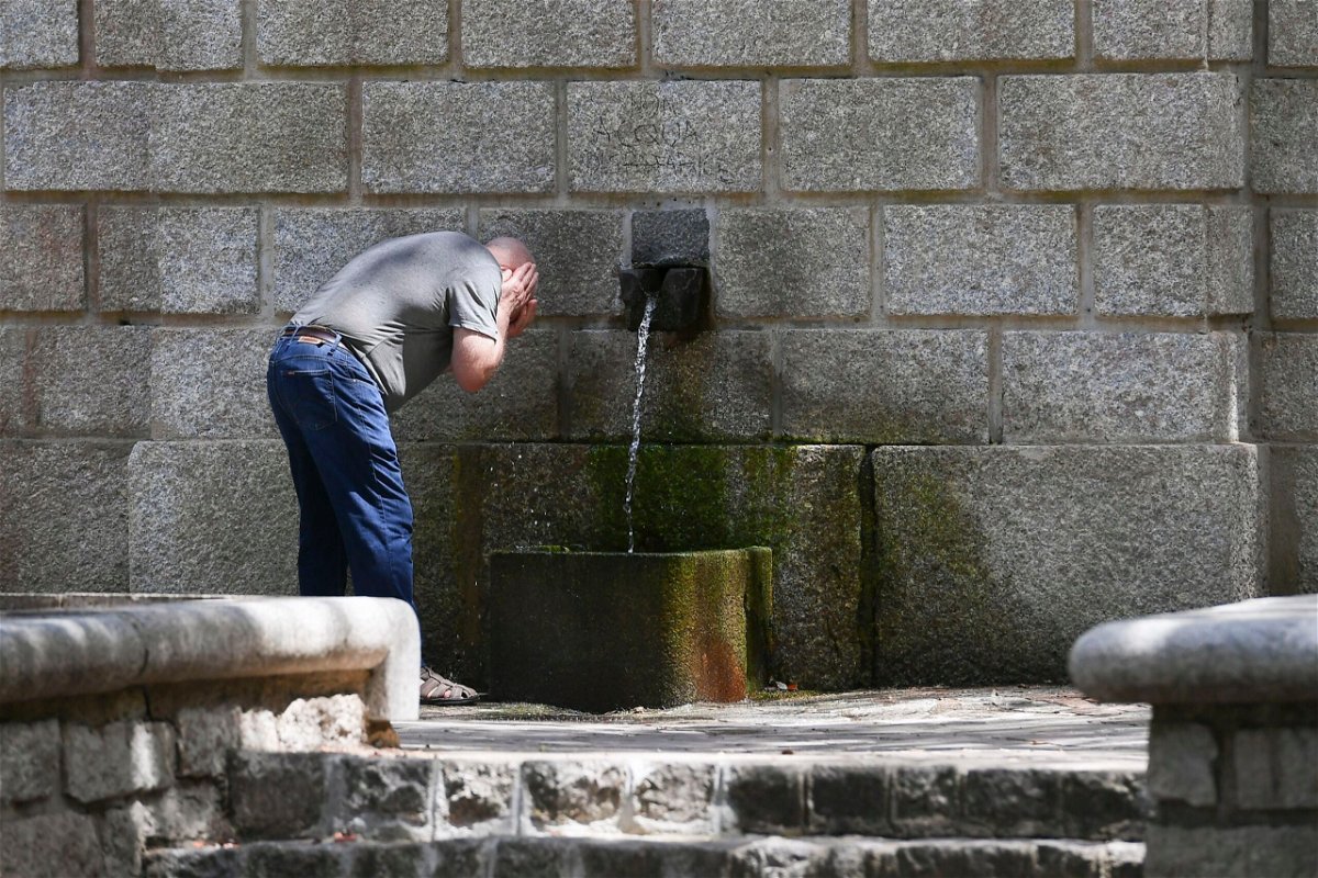 <i>Emanuele Perrone/Getty Images</i><br/>A man refreshes his face in a public fountain on July 11