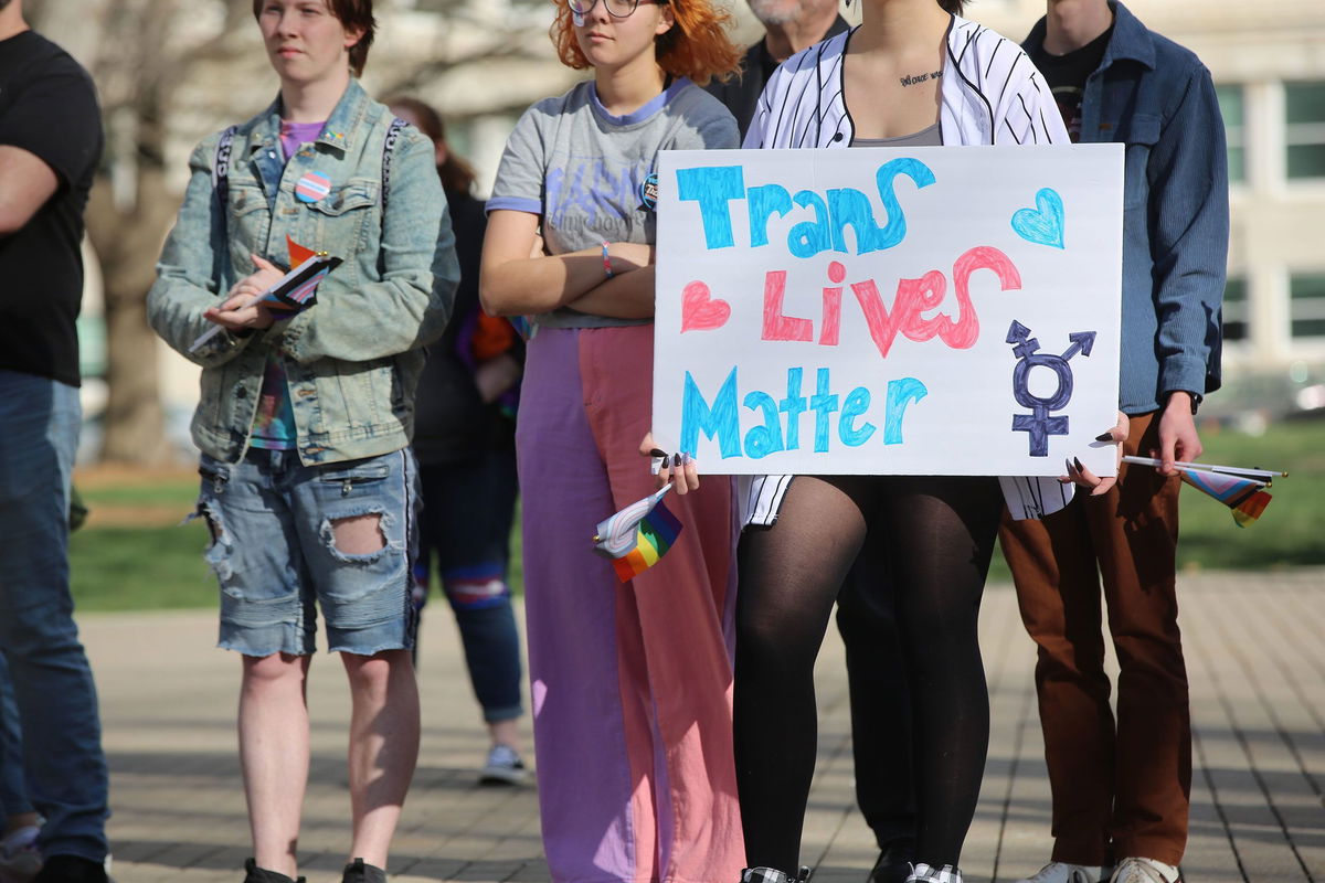 <i>Andrew Bahl/The Topkea Capital-Journal/USA Today Network</i><br/>A demonstrator listens to speakers at a rally held in support of transgender youth in Kansas. It comes amid a raft of anti-transgender legislation in the Sunflower State.