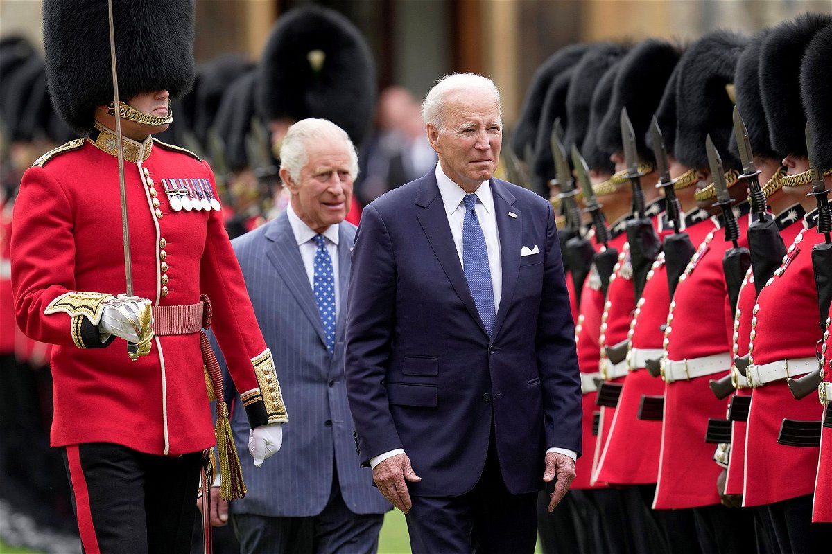 <i>Kin Cheung/Reuters</i><br/>U.S. President Joe Biden and Britain's King Charles review an honorary guard at Windsor Castle in Windsor